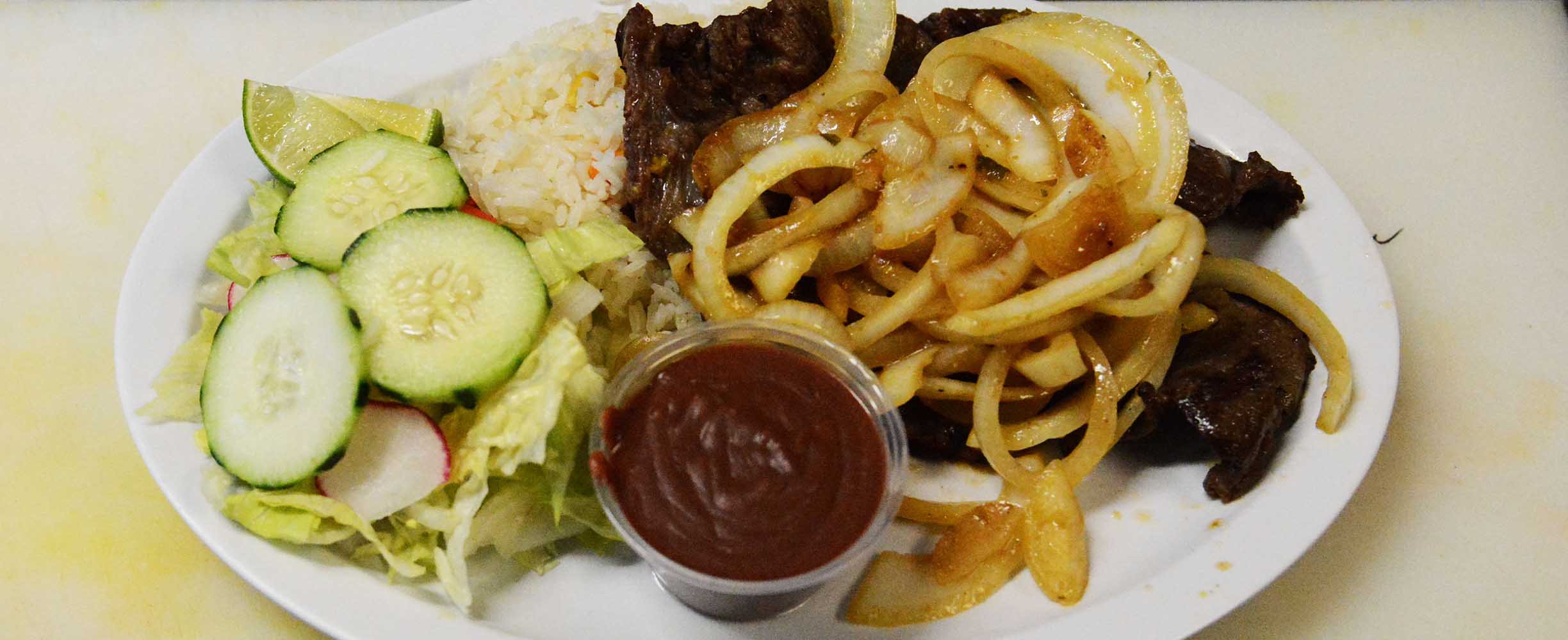 Carne encebollada, or beef with onions and sald on the side, it's a well rounded sich with protein, rice, and slad.